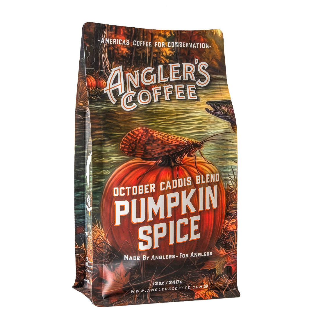 A 12 oz bag of Angler's Coffee 'Pumpkin Spice' October Caddis Blend, featuring a detailed autumn and fishing illustration on the packaging.