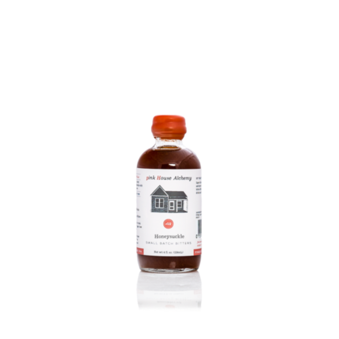Bottle of pink house alchemy honeyuckle syrup on a white background