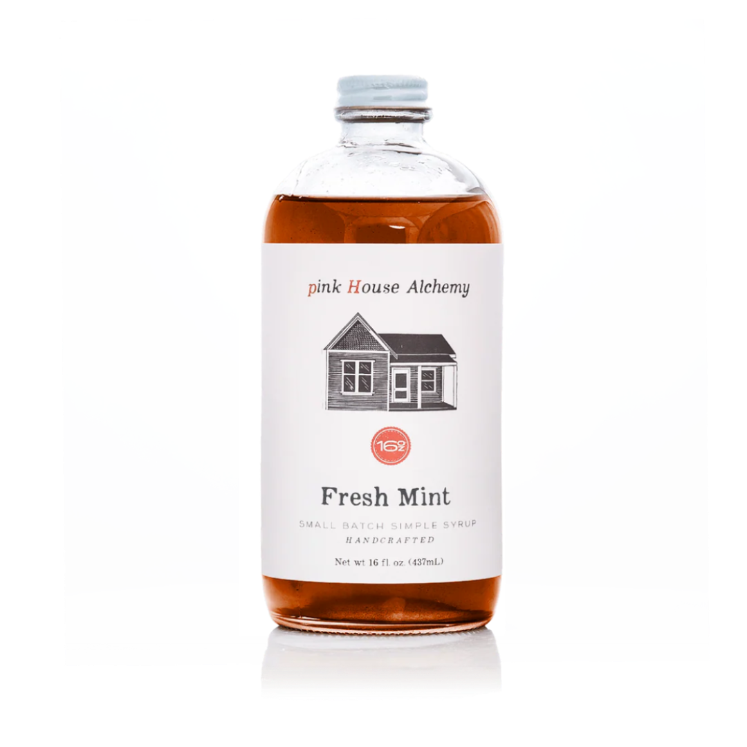 A bottle of pink House Alchemy Fresh Mint simple syrup with amber liquid inside, a white label with a house illustration, and a silver cap, shown on a white background.