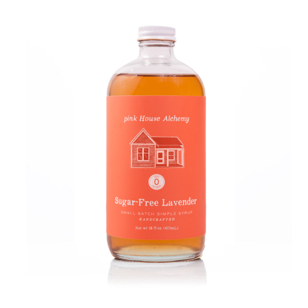 A bottle of pink house alchemy sugar-free lavender syrup with a bright coral-orange label and white cap, set against a clean white background.