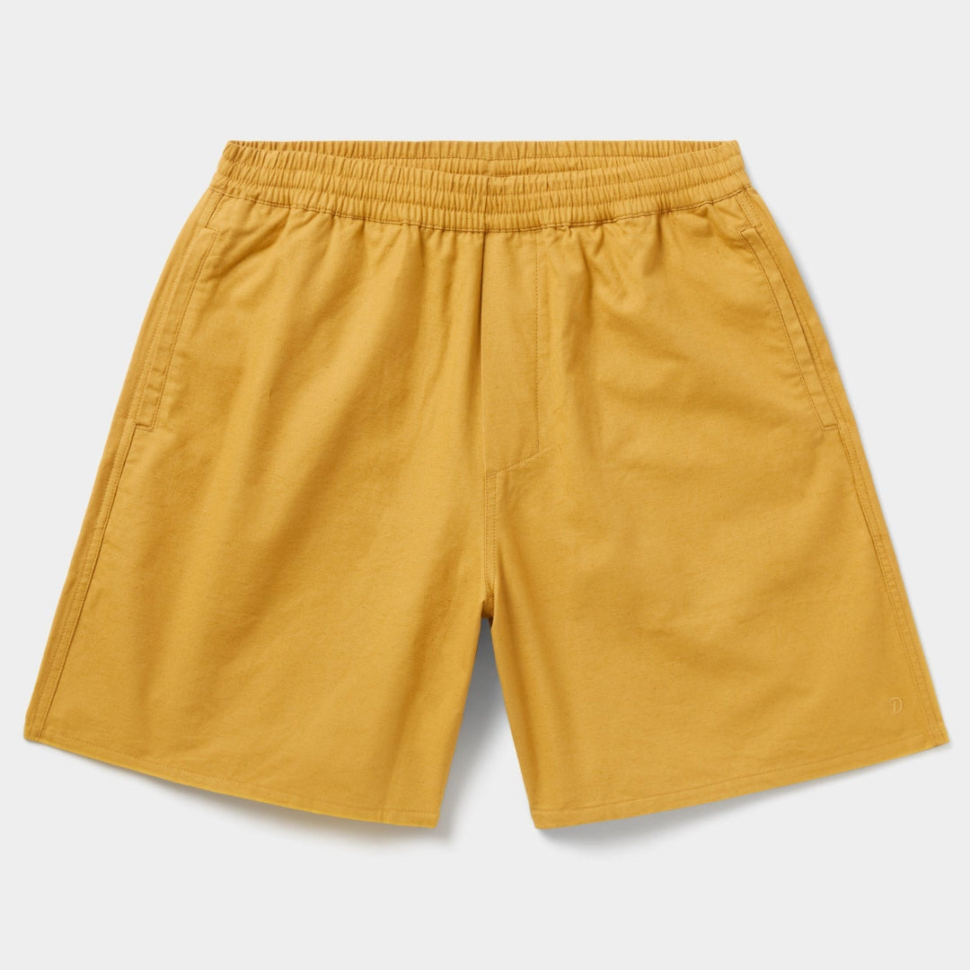 Mustard yellow shorts on a light gray background