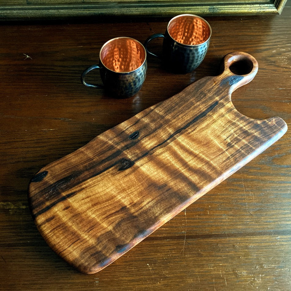 This Charcuterie Board is crafted from Old Growth Redwood live edge to give outstandingly unique color and grain. A real statement piece, it is perfect for entertaining with friends and cocktails on the patio. Seasoned and finished with Milie's Penetrating Tung Oil, it is best used for serving and not cutting.  Presentation on both sides.