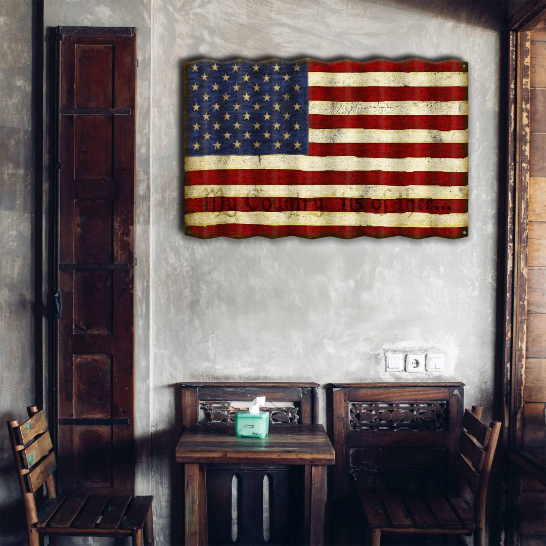 Rustic American flag on a textured wall above wooden furniture.