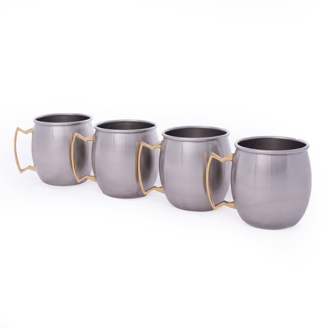 Four Moscow mule style metal mugs with gold-tone handle accents, arranged in a diagonal row on a white background.